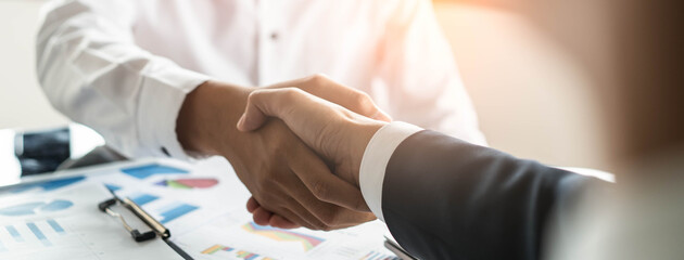 Banker and client shaking hands after business loan grant.