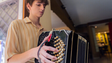 Teen musician plays bandoneon in a cozy cafe during afternoon performance