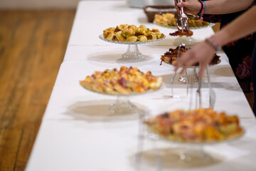 Delicious Assortment of Savory Pastries and Tarts Displayed on a White Table Ready for Guests at a Festive Event Gathering Catering Service