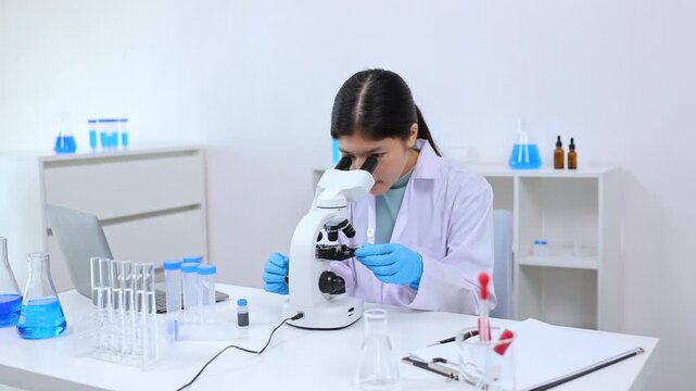 Teen girl observing a sample under the microscope during experiment. Science, laboratory, scientist, experiment, and research express hands-on learning and curiosity in a lab environment, healthcare.