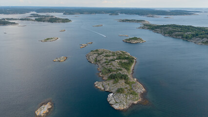 Aerial View of Rocky Islands Scattered Across the Calm Sea Near Str&ouml;mstad, Sweden with Sparse Vegetation and a Boat Wake Cutting Through the Water
