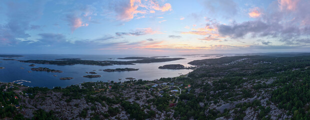 Panoramic Aerial View of Rocky Coastline and Islands Near Str&ouml;mstad, Sweden at Dusk with Dramatic Clouds and Vibrant Sunset Colors Over the Calm Sea
