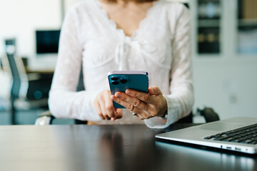 Businesswoman hand working digital marketing media in virtual screen with mobile phone and modern compute with VR icon diagram at office in morning light