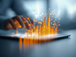 Person interacting with glowing orange digital data charts projected above tablet representing technology innovation and advanced data analysis trends