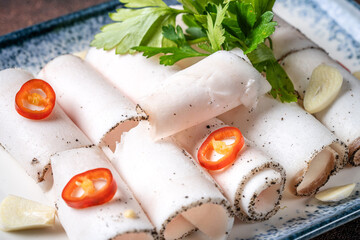 Closeup of rolled pork fat with chili and garlic