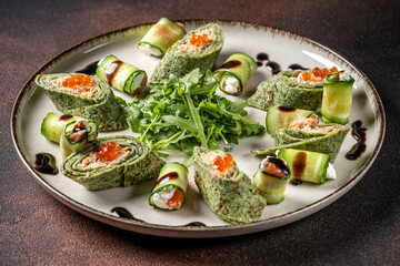 Spinach crepes with salmon and cucumber rolls