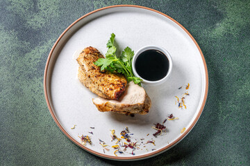Grilled chicken fillet with dark sauce and herbs