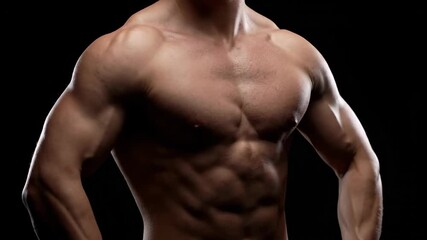 Strong Male Athlete Posing with Defined Muscles on Dark Background