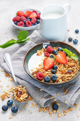 Granola bowls with berries, yogurt, nuts, and honey for breakfast