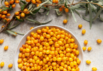 Sea buckthorn berries in bowl with branches