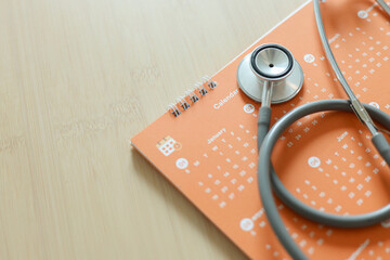 close up top view on stethoscope on calendar with over table background for design about ads or...
