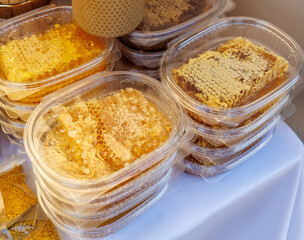 A stack of plastic containers with honey in them