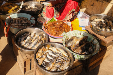 Fresh fish and seafood displayed in metal and plastic bowls under the tropical sun at a traditional Cirebon market. daily trade, local livelihood, Indonesia's coastal resources, maritime culture
