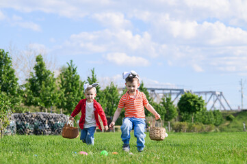 Obraz premium Kids Hunting Easter Eggs Outdoors on Sunny Spring Day