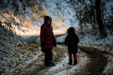 Mother and child walking together on snowy winter path