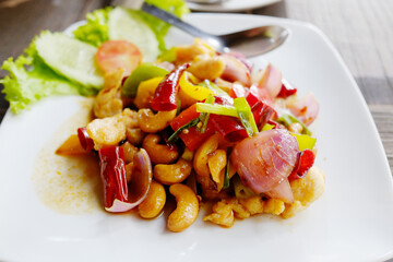 Stir fried spicy cashew nuts in white dish. Tradition food in Thailand
