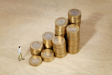 Stack of coin and businessman figurine - Concept of money investment and growth
