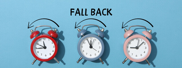 Three alarm clocks indicating time change for fall back
