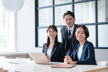 社内で笑顔のカメラ目線の男女