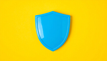 Blue glossy shield symbol on yellow background. Protection, safety and cybersecurity concept.