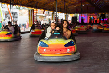 Friends enjoying bumper car ride at fair with laughter and vibrant lights