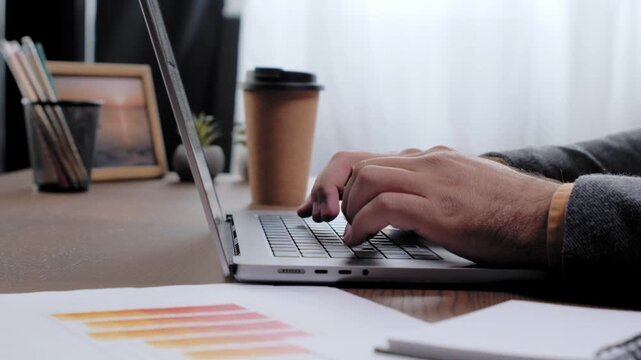 Male hands typing on laptop keyboard