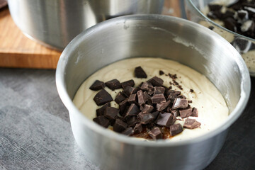 Preparing chocolate mousse in a metal mixing bowl, closeup