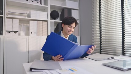 Asian businessman working and checking document on clipboard in office.  - Powered by Adobe