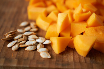 Sliced pumpkin with seeds on a cutting board. Selective focus.