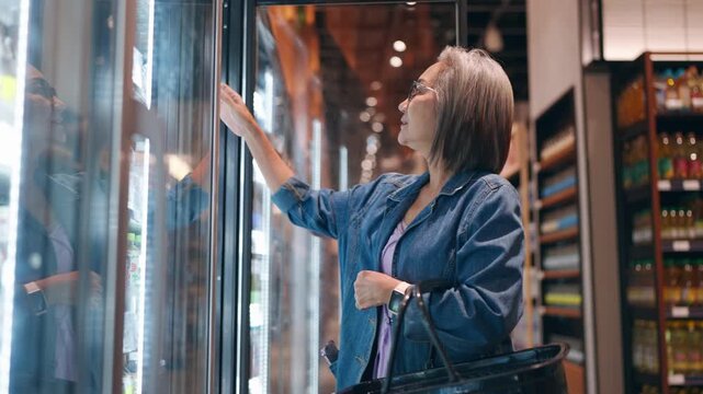 Asian senior elderly woman shopping for groceries in a supermarket. 