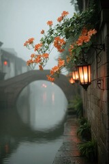On a foggy day, streetlights hang on the walls of buildings in the water town, and orange flowers are next to them.