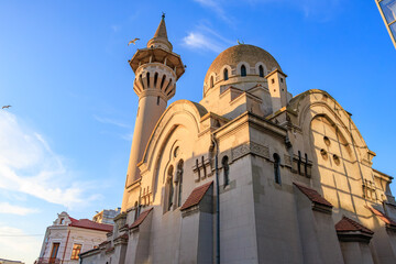 Historical mosque at sunset with birds in blue sky
