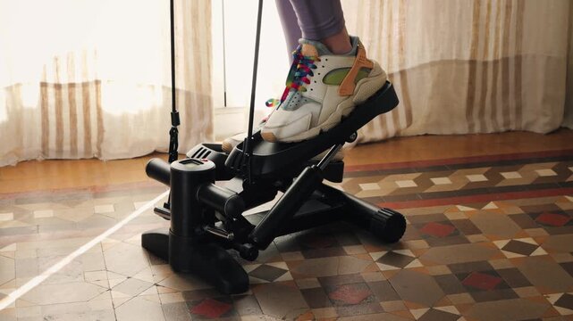 Legs with sneakers working out at home on stepper close up footage. High quality 4k footage