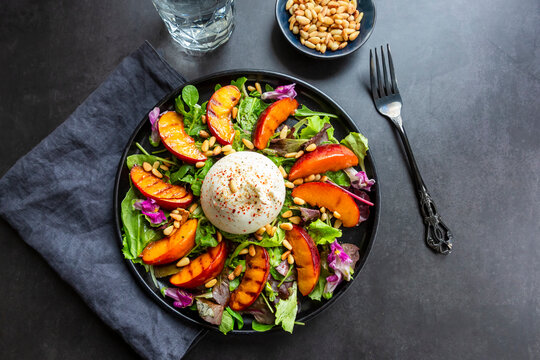Grilled nectarine salad with burrata, pine nuts and edible flowers