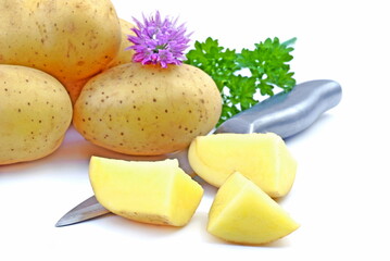 Fresh raw potatoes, whole and sliced, with parsley and knife isolated on white background.