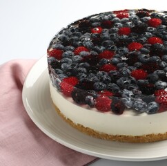 Delicious cheesecake with berries on white table, closeup