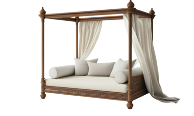 A wooden four-poster canopy daybed with flowing drapes, woven base, plush cushions and bolsters, featuring carved posts and neutral upholstered mattress.