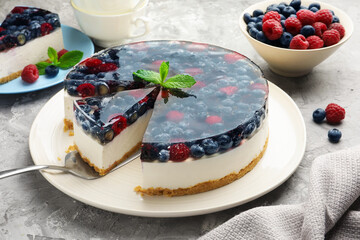 Taking piece of delicious cheesecake with berries at grey table, closeup