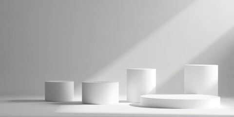 Minimalist display of white geometric shapes on a light background. Various cylindrical forms arranged in a modern style. Ideal for product showcasing.