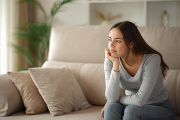 Relaxed woman thinking and looking away at home