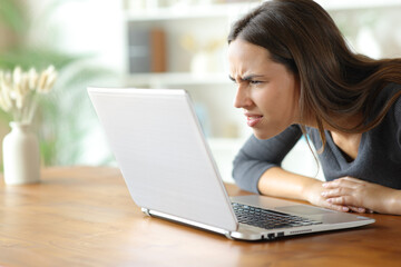 Woman with vision problems forcing sight reading on laptop