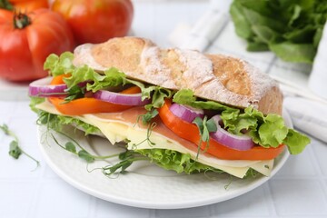 Delicious ciabatta sandwich with prosciutto, cheese and vegetables on white tiled table, closeup