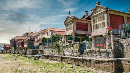 Hilera de tradicionales hórreos gallegos en la villa de Combarro durante la marea baja, provincia...