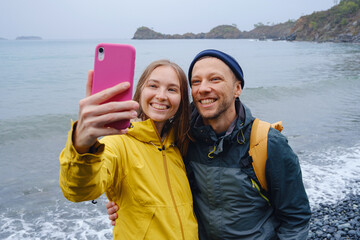 Couple taking selfie on beach in Winter