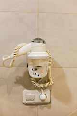 hair dryer hanging on the wall bathroom hotel