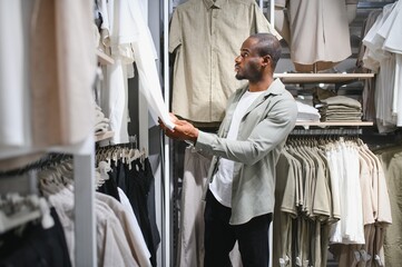 Stylish man shopping for clothes at mall
