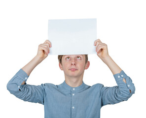 Confused teenage boy keeps a blank paper sheet over head looks up bewildered. Male adolescent...