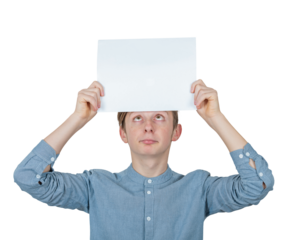 Confused teenage boy keeps a blank paper sheet over head looks up bewildered. Male adolescent portrait holding an empty banner placard, isolated on transparent background