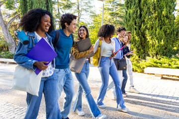 Diverse students walking and laughing on campus path