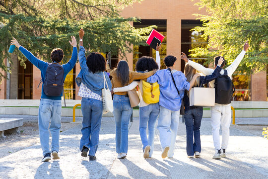 Diverse students group celebrating walking away on campus